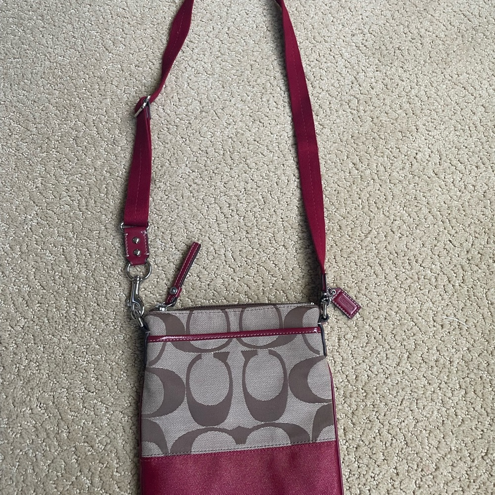 Coach messenger crossbody signature canvas with red trim.